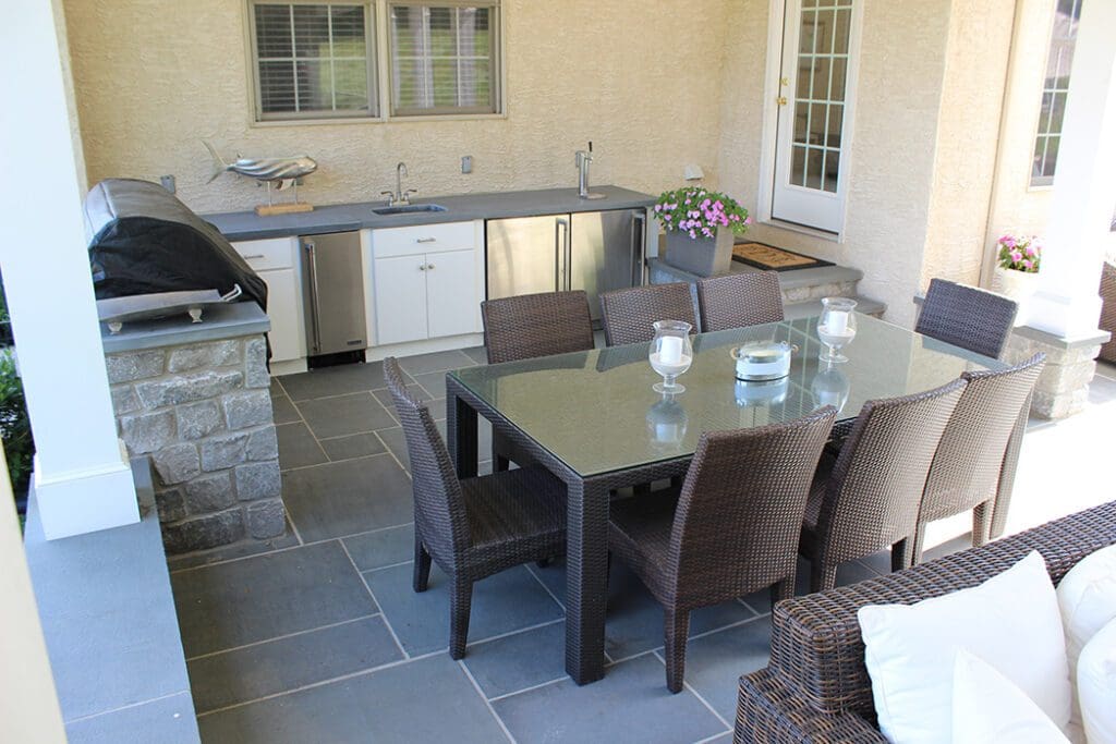 An outdoor pavilion with a fireplace and kitchen.