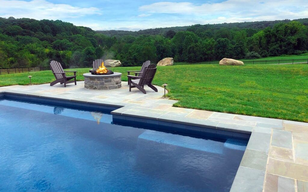 Outdoor fire pit in large backyard by pool