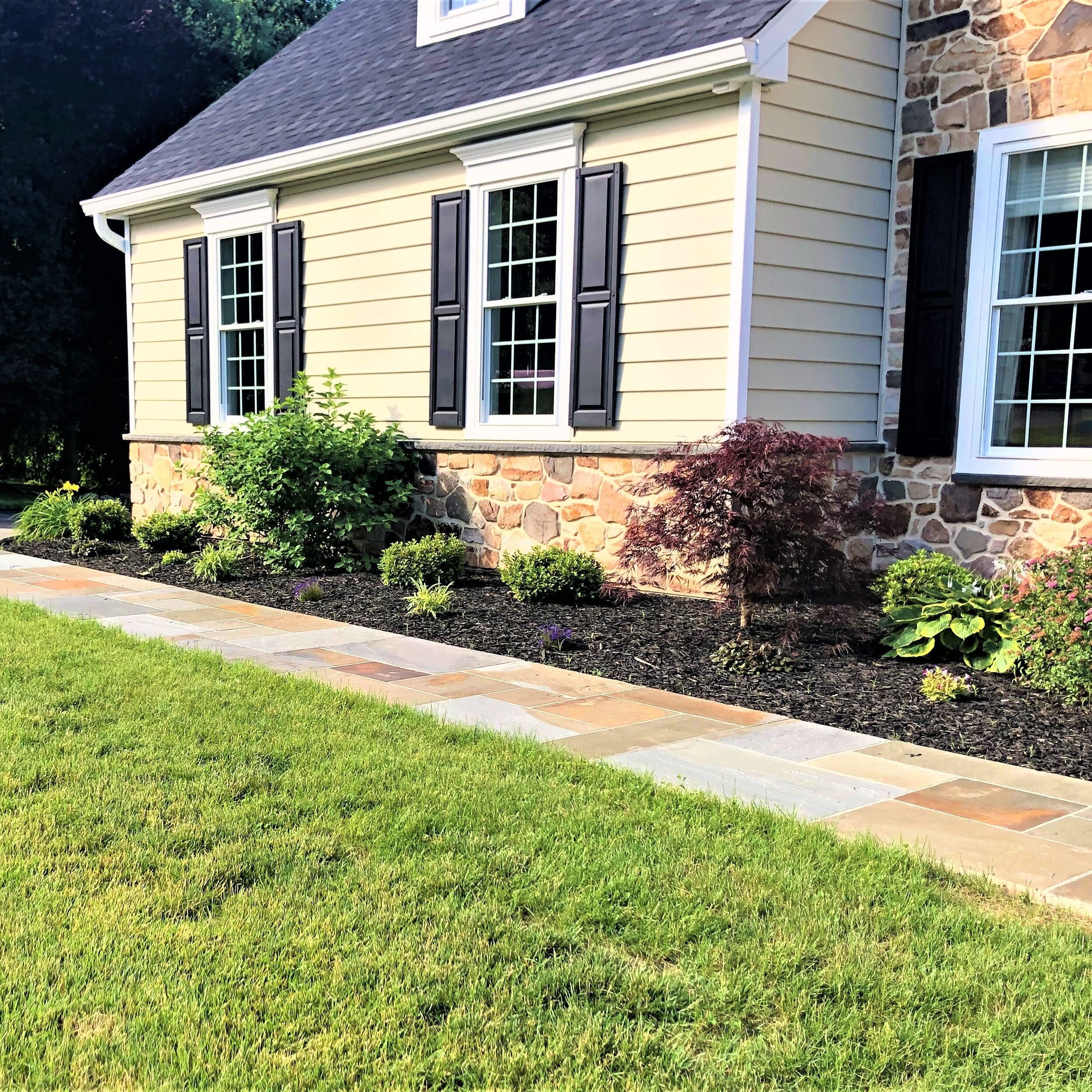 A home with a stone walkway and a thin stone veneer exterior.