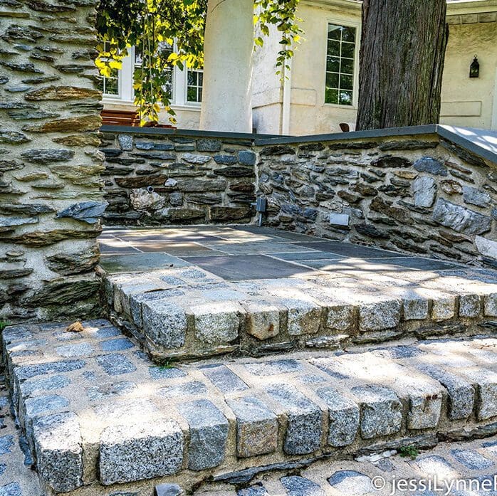 Wide stone stairs with a veneer stone sitting wall.