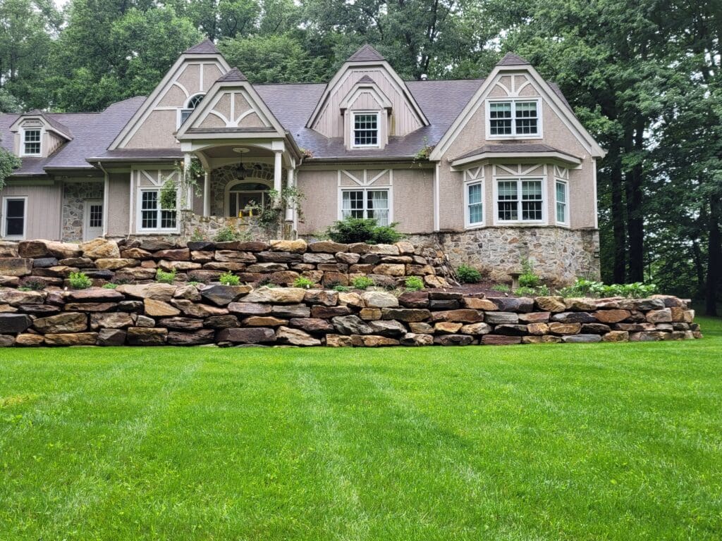 a home on a hill with a stone retaining wall
