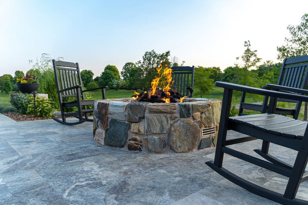 a stone fire pit on a backyard patio