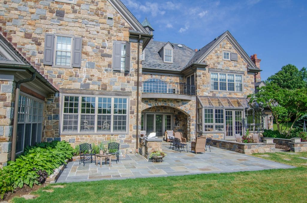 a house with a stone patio and landscaping