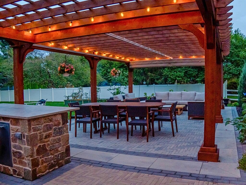 Explore this custom outdoor kitchen and pergola transformation featuring an integrated masonry pizza oven, Blaze appliances, and a Techo-Bloc Westmount paver patio