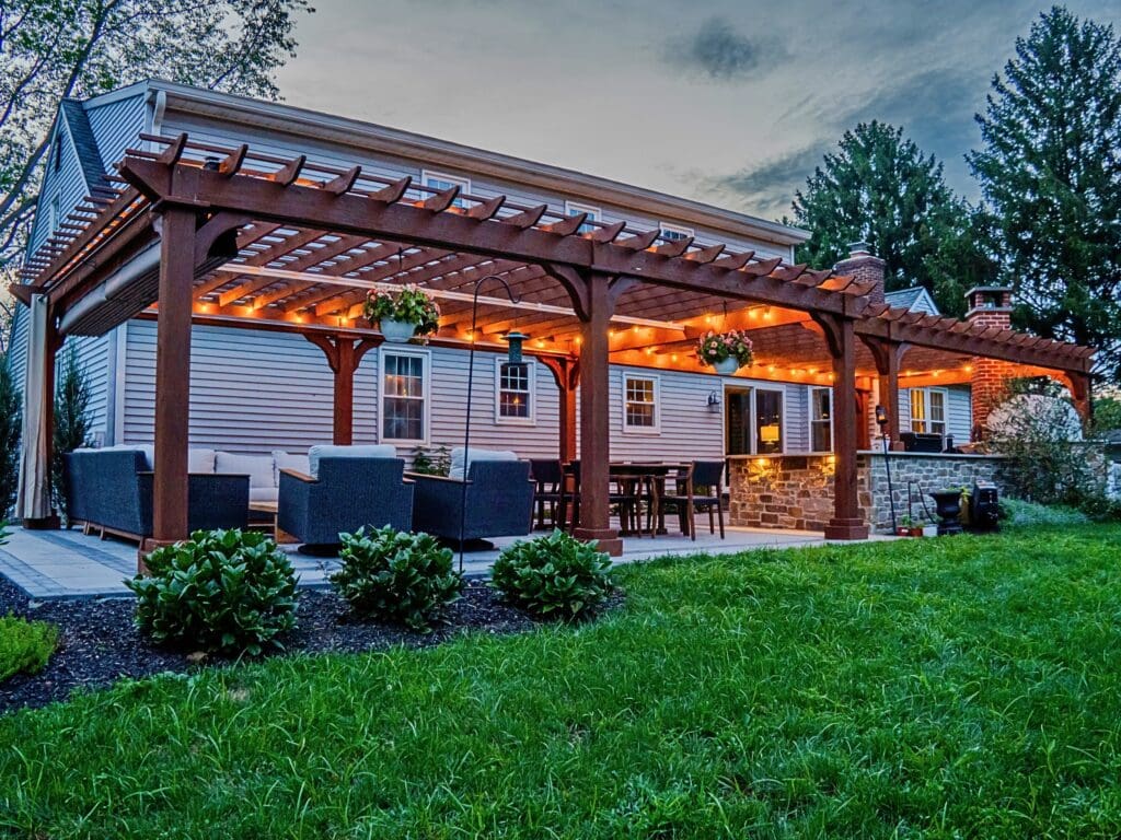 Explore this custom outdoor kitchen and pergola transformation featuring an integrated masonry pizza oven, Blaze appliances, and a Techo-Bloc Westmount paver patio