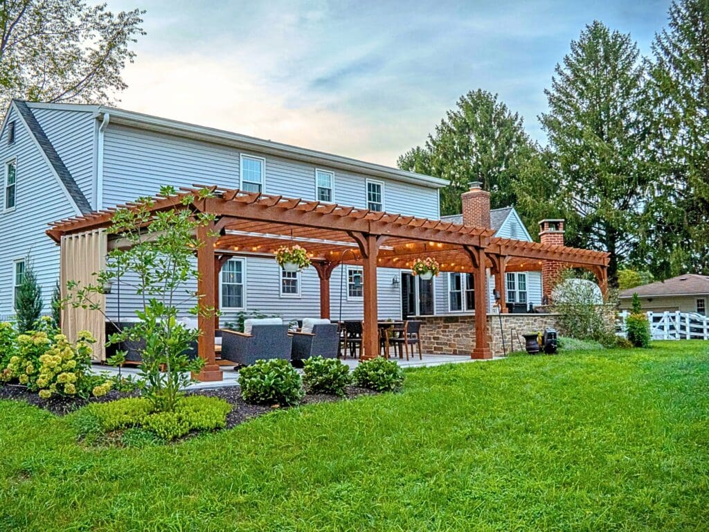 Explore this custom outdoor kitchen and pergola transformation featuring an integrated masonry pizza oven, Blaze appliances, and a Techo-Bloc Westmount paver patio